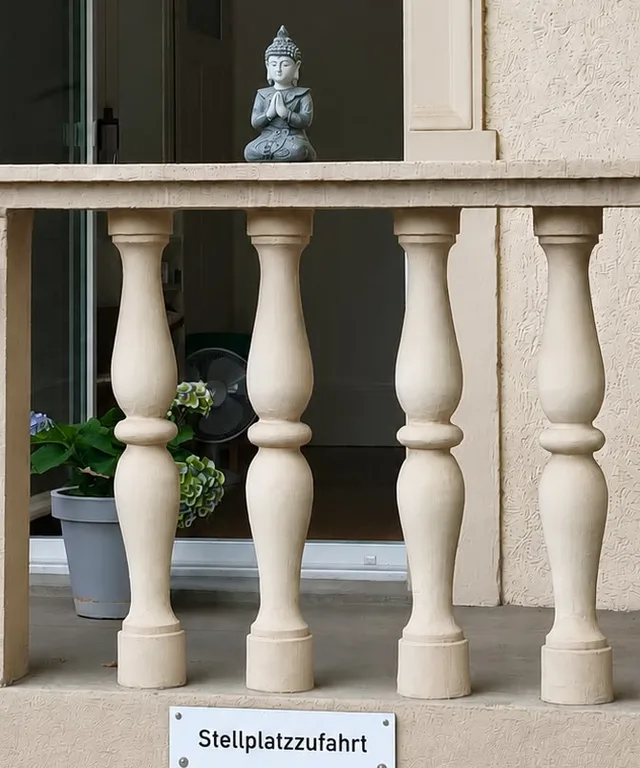 Balustrade mit Buddha-Figur an der Stellplatzzufahrt